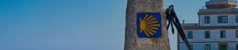 camino de santiago waymarker with scallop shell symbol at finisterre lighthouse